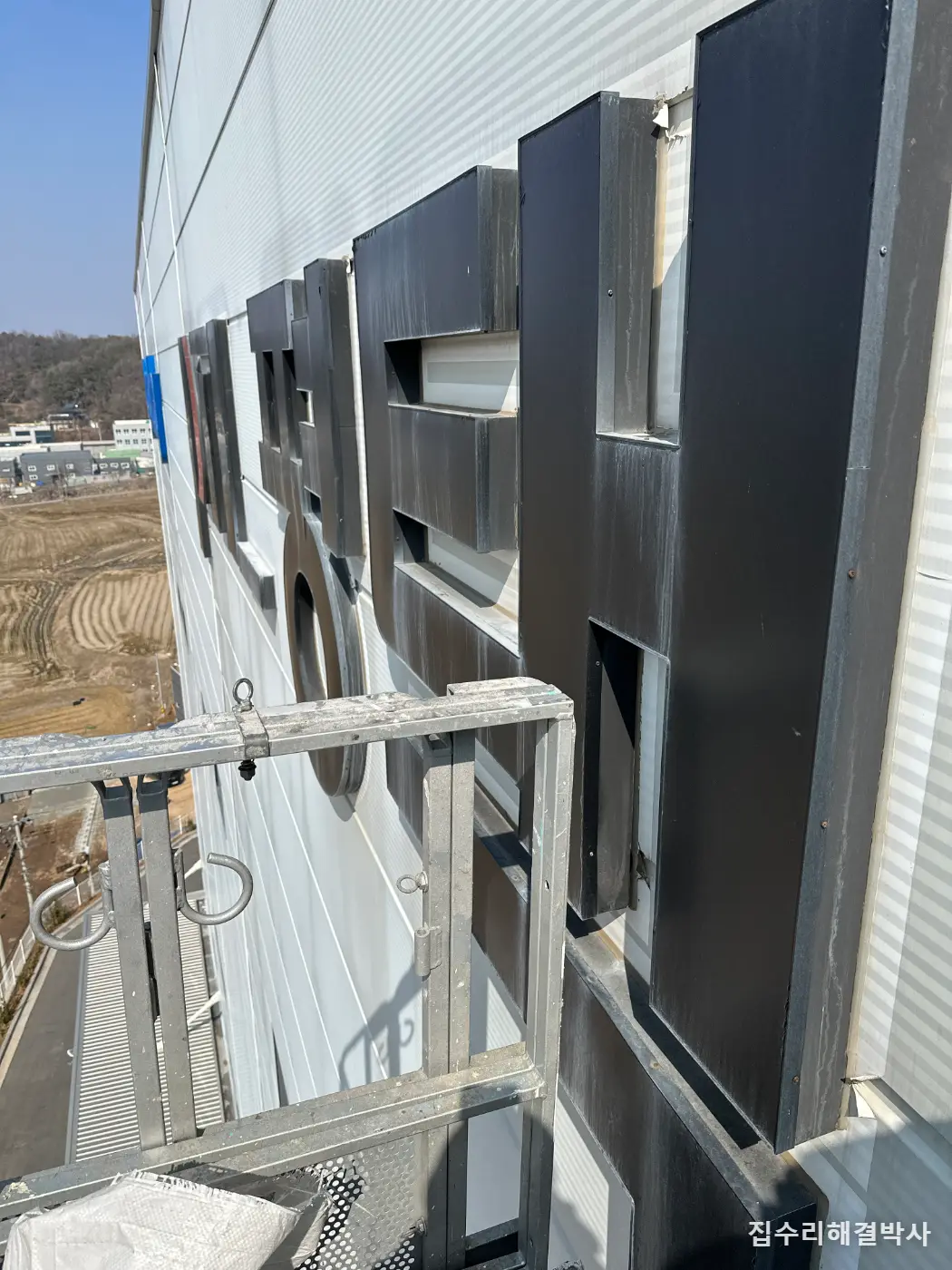 물류창고 외벽 판넬 간판 철거 — 필름·접착제·물때까지 걷어내 판넬을 되돌린 방법 시공 사진 2